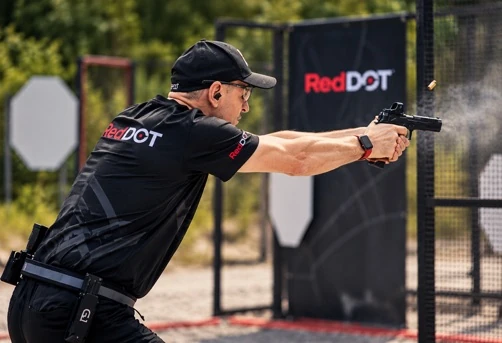 Michał Gonciarz podczas strzelania z pistoletu na strzelnicy plenerowej